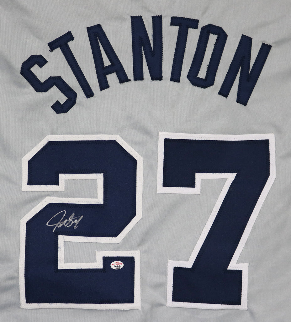 Giancarlo Stanton holds up his new No. 27 Yankees jersey.